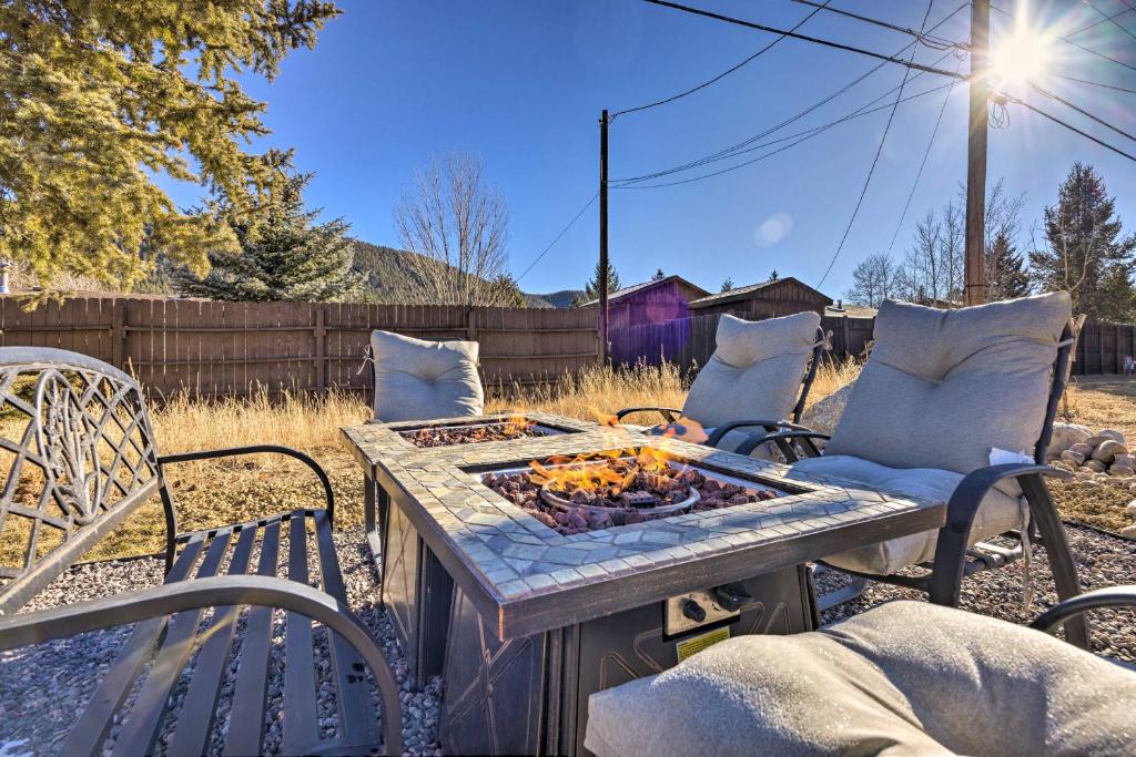 a patio with a table and chairs and a fire pit at Hike, Bike and Fish Gem with Hot Tub in Woodland Park in Woodland Park