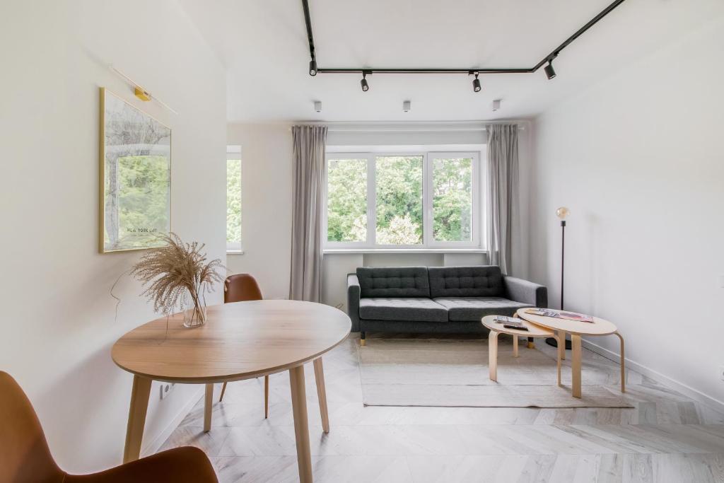 uma sala de estar com uma mesa e um sofá em Central Apartment in Architectural Street em Kaunas