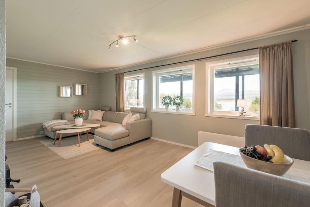 een woonkamer met een bank en een tafel bij Spacious modern apartment, close to nature in Tromsø