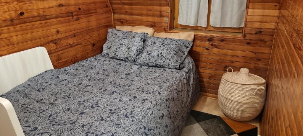 uma cama e almofadas num quarto com paredes de madeira em CHAMBRE PRIVÉE Numéro 3 dans un Superbe appartement en colocation em Montataire