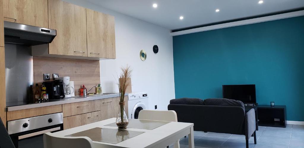 een keuken en een woonkamer met een tafel en een bank bij Le Délice doré - Wifi - Parking Privée in Lens