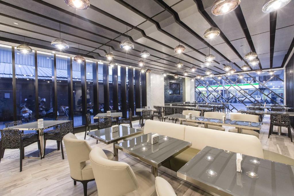 a restaurant with tables and chairs and windows at The Cloud Hotel in Taichung