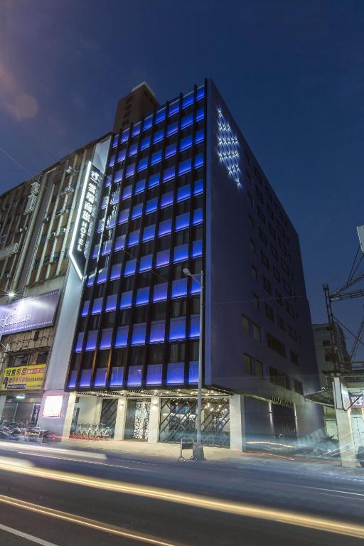 un edificio alto con ventanas azules en una calle de la ciudad en The Cloud Hotel, en Taichung
