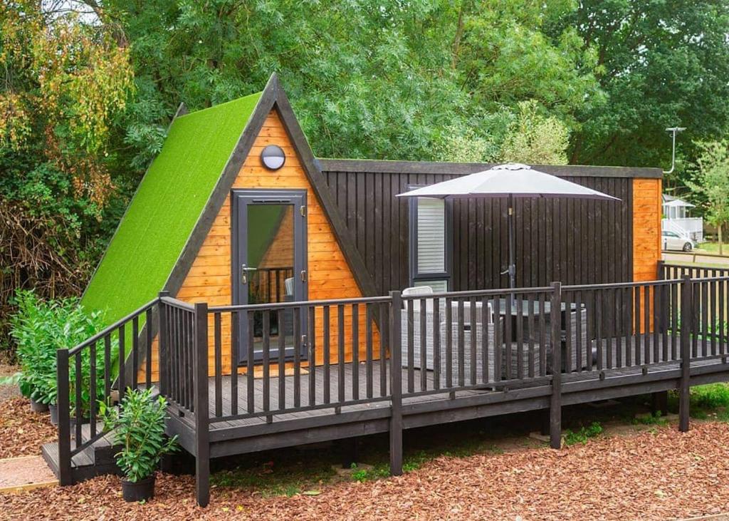 a small childs play house with a green roof at Lee Valley Sewardstone in Enfield Lock