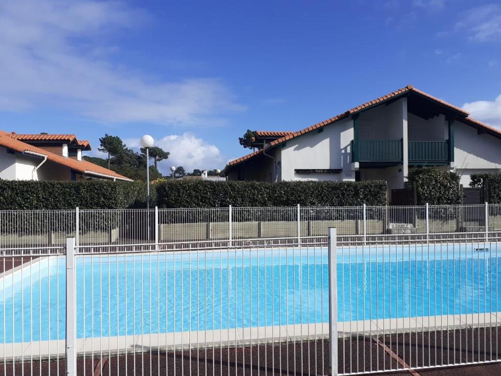 une piscine bleue devant une maison dans l'établissement Villa Patio pour 6 avec Piscine et Parking Privé, à 2000m des Plages de Capbreton - FR-1-239-748, à Capbreton