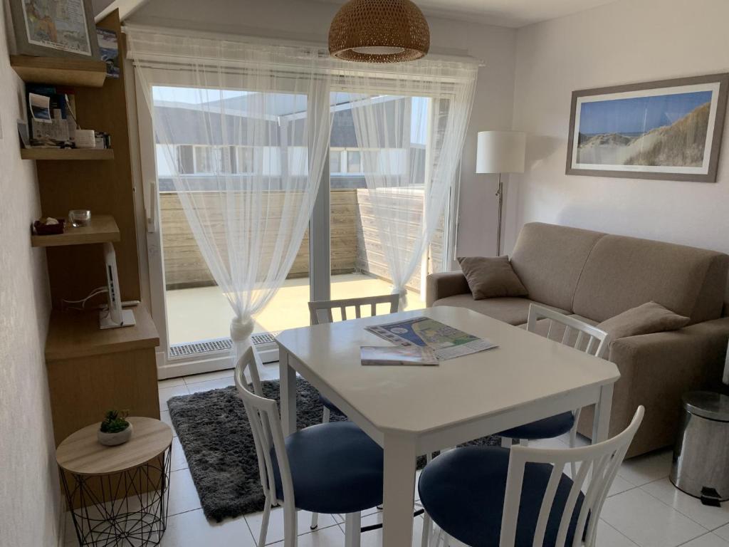a living room with a table and a couch at Appartement proche plage avec parking et balcon - FR-1-482-102 in Fort-Mahon-Plage