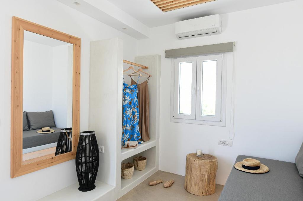 a room with a mirror and a bed and a window at Ios Art Suites in Ios Chora