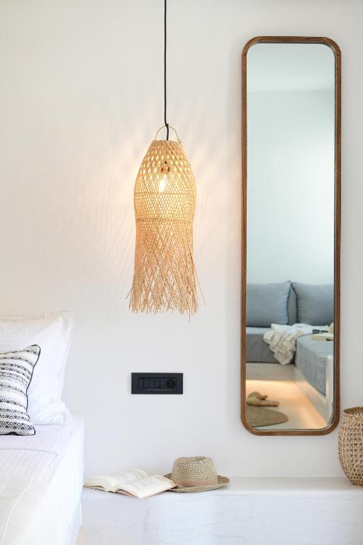 a mirror and a pendant light in a bedroom at Ios Art Suites in Ios Chora