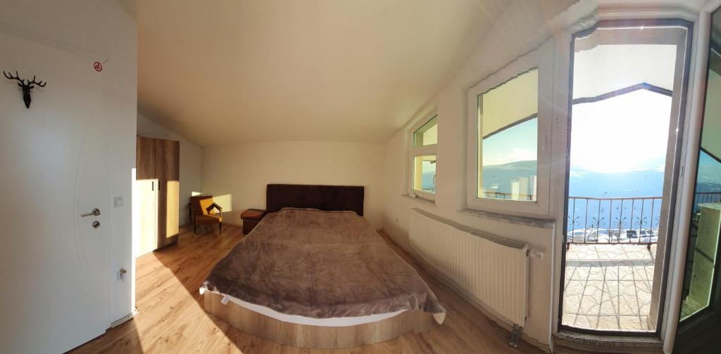 a bedroom with a bed and a large window at Villa Winterfell Popova Shapka in Popova Shapka