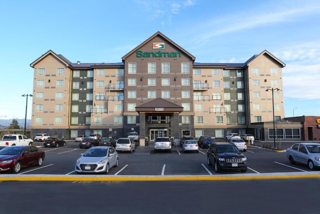 a large building with cars parked in a parking lot at Sandman Hotel Abbotsford Airport in Abbotsford