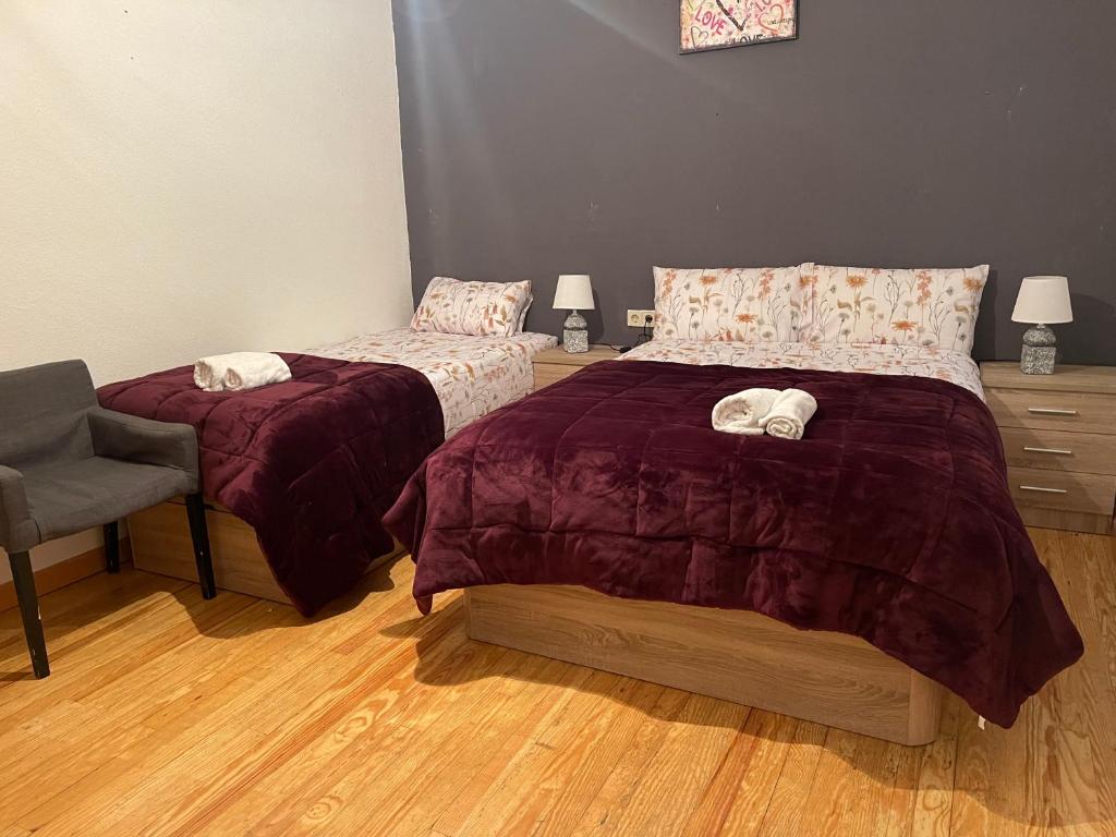 1 dormitorio con 2 camas y 1 silla en Piso san Marcos madrid, en Madrid