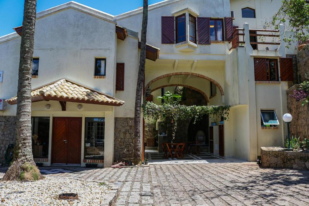 a house with a courtyard with a palm tree at Hostel Jardim das Bruxas 410 in Florianópolis