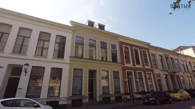 un edificio en una calle con coches aparcados delante en De Pikeur, en Deventer