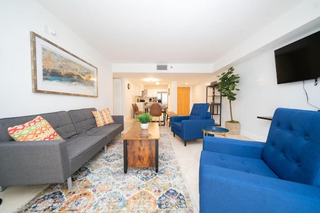 - un salon avec deux canapés bleus et une télévision dans l'établissement 2Bed 2 Bath Airbnb Friendly building with Pool, Hot Tub, and Gym, à Miami