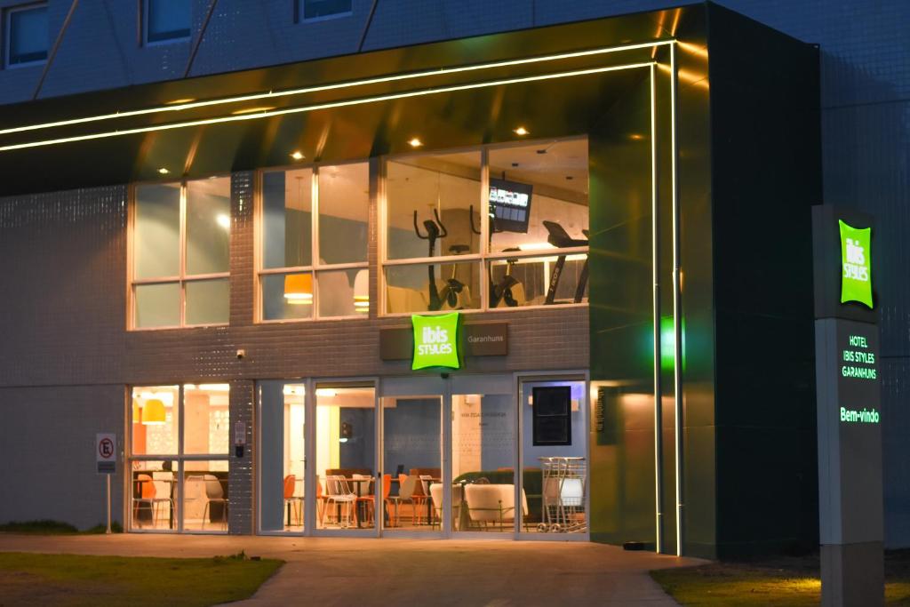 a building with a balcony with chairs in it at night at Ibis Styles Garanhuns in Garanhuns