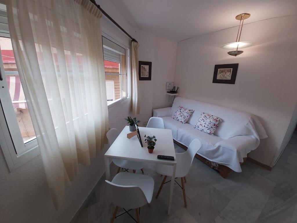 a room with a couch and a table and a window at Apartamento Sostoa 4 in Málaga