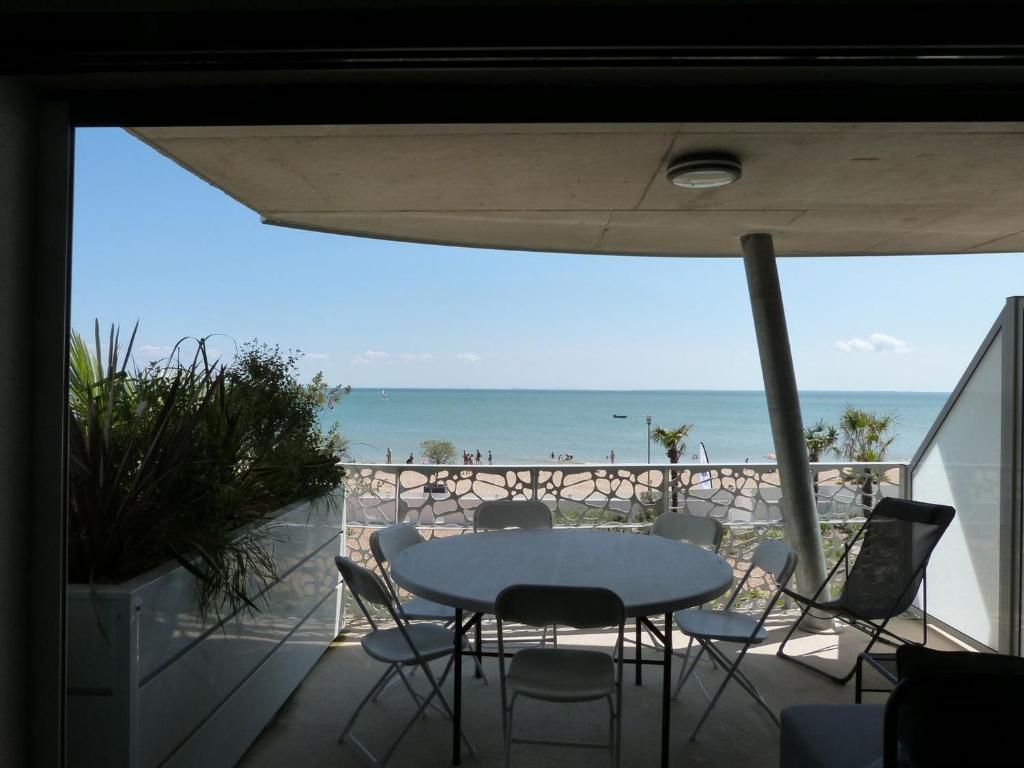 uma mesa e cadeiras numa varanda com vista para a praia em Appartement La Tranche-sur-Mer, 3 pièces, 6 personnes - FR-1-194-234 em La Tranche-sur-Mer
