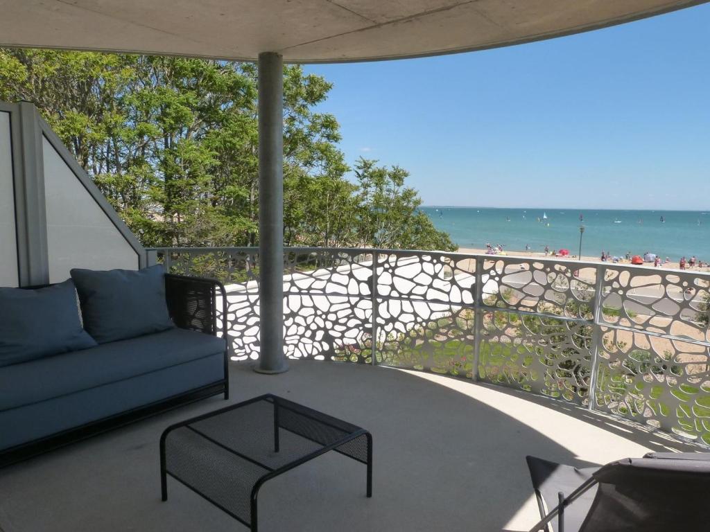 a living room with a couch and a view of the beach at Appartement 2 chambres, balcon, accès plage, piscine, parking, animaux admis - La Tranche-sur-Mer - FR-1-194-232 in La Tranche-sur-Mer