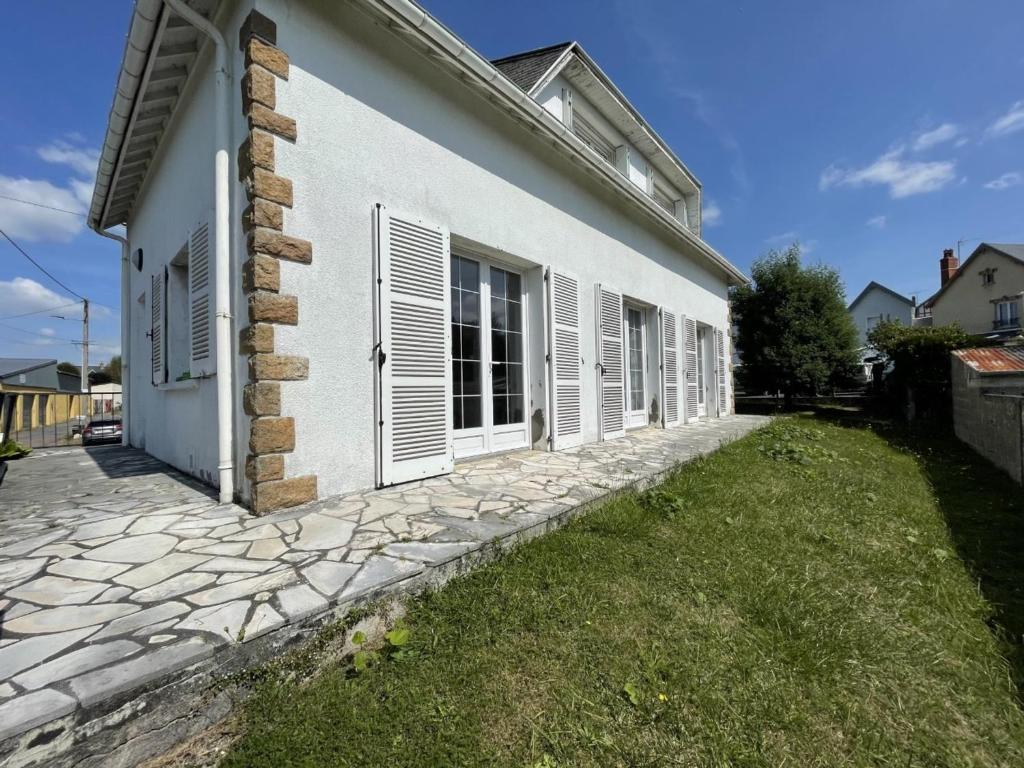 een wit huis met een stenen pad naast een gebouw bij Maison Donville-les-Bains, 4 pièces, 7 personnes - FR-1-361-425 in Donville-les-Bains