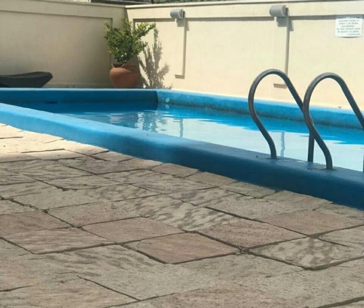 una piscina azul con dos barras de metal. en MZA Departamentos en Mendoza