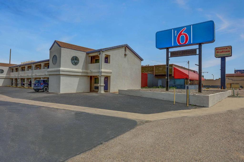 um posto de gasolina com um sinal em frente em Motel 6-Clovis, NM em Clovis