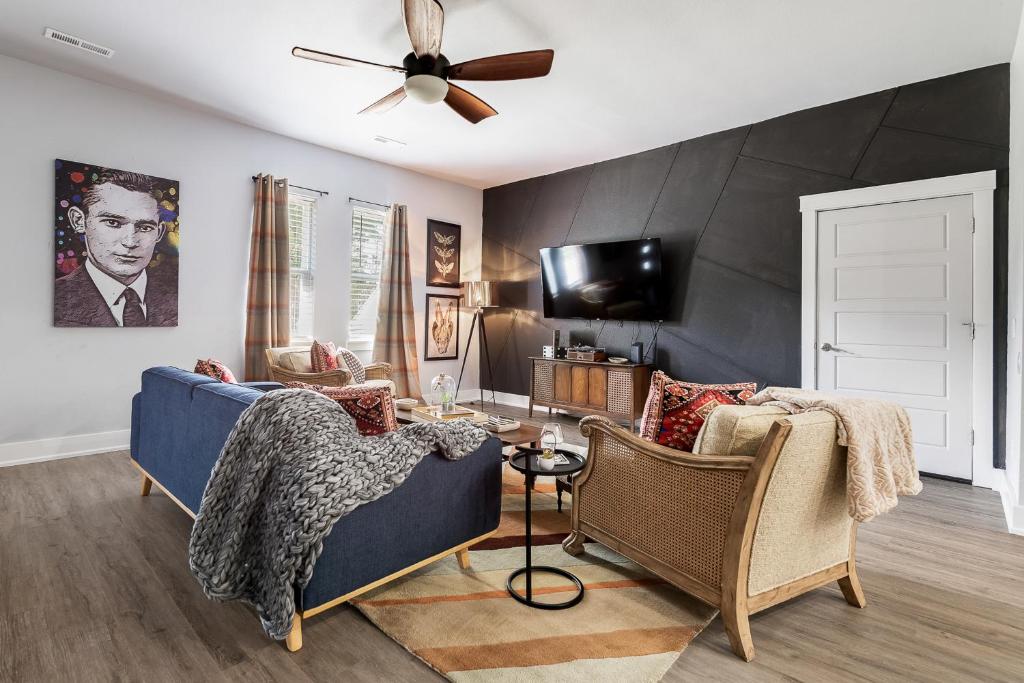 a living room with a blue couch and a ceiling fan at The Sam in Bentonville