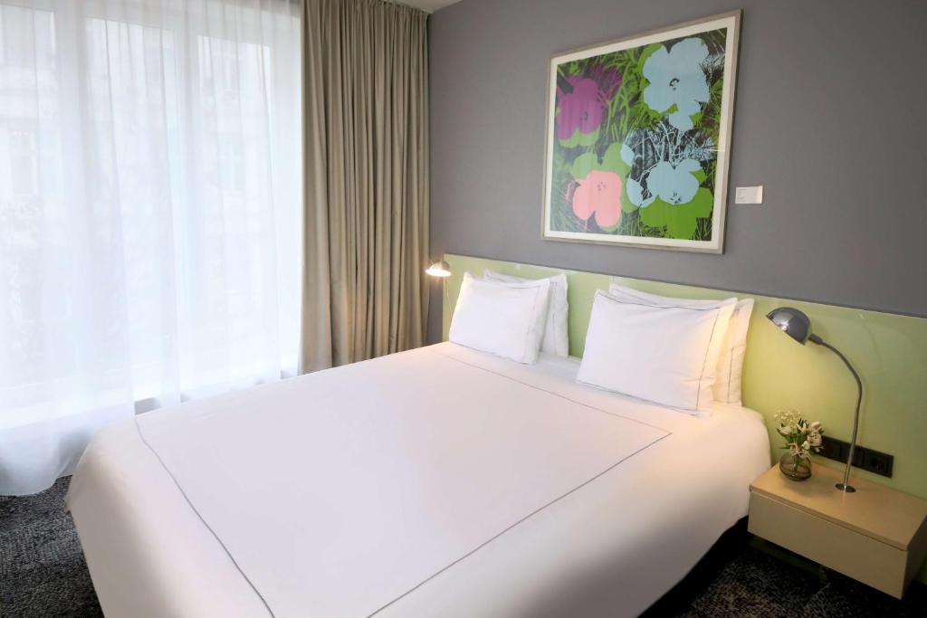 duże białe łóżko w pokoju hotelowym w obiekcie Park Plaza Berlin w Berlinie