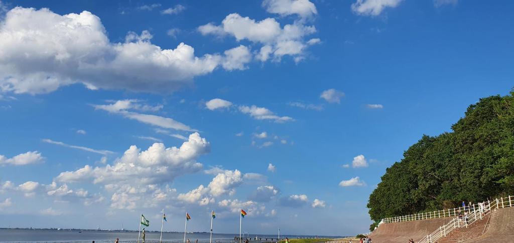 a group of flags on a beach under a cloudy sky at Ferienwohnung Hansens in Dangast