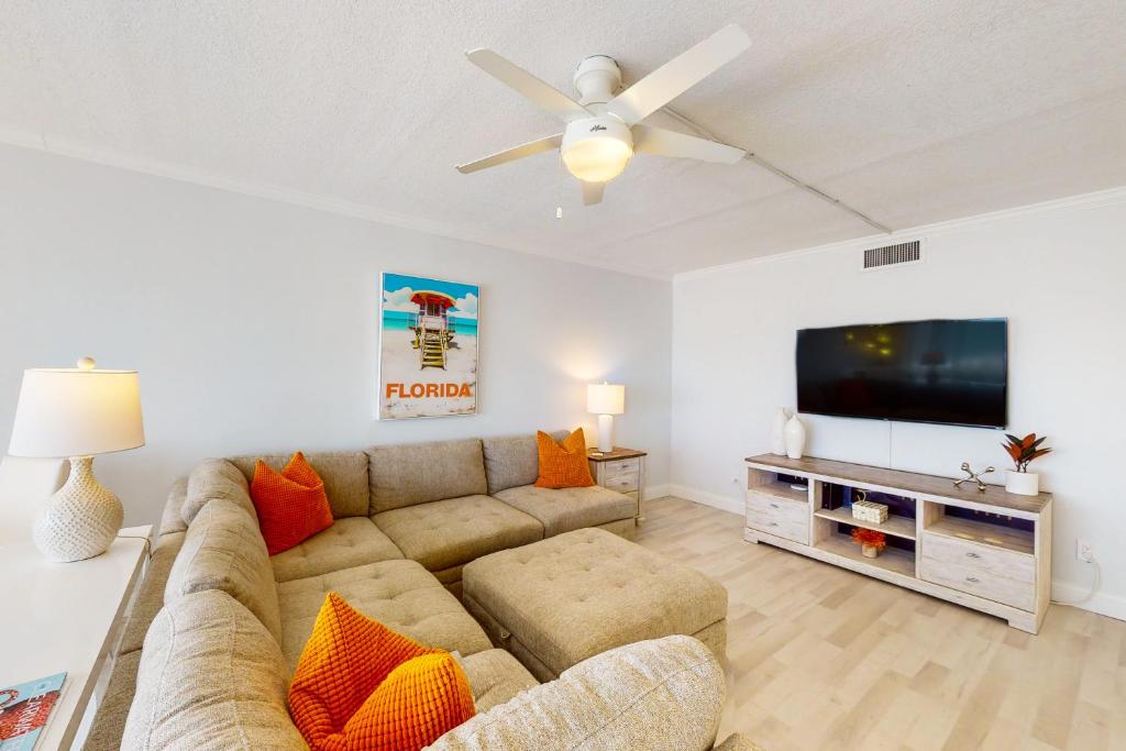 een woonkamer met een bank en een flatscreen-tv bij Paralia Condo in Clearwater Beach