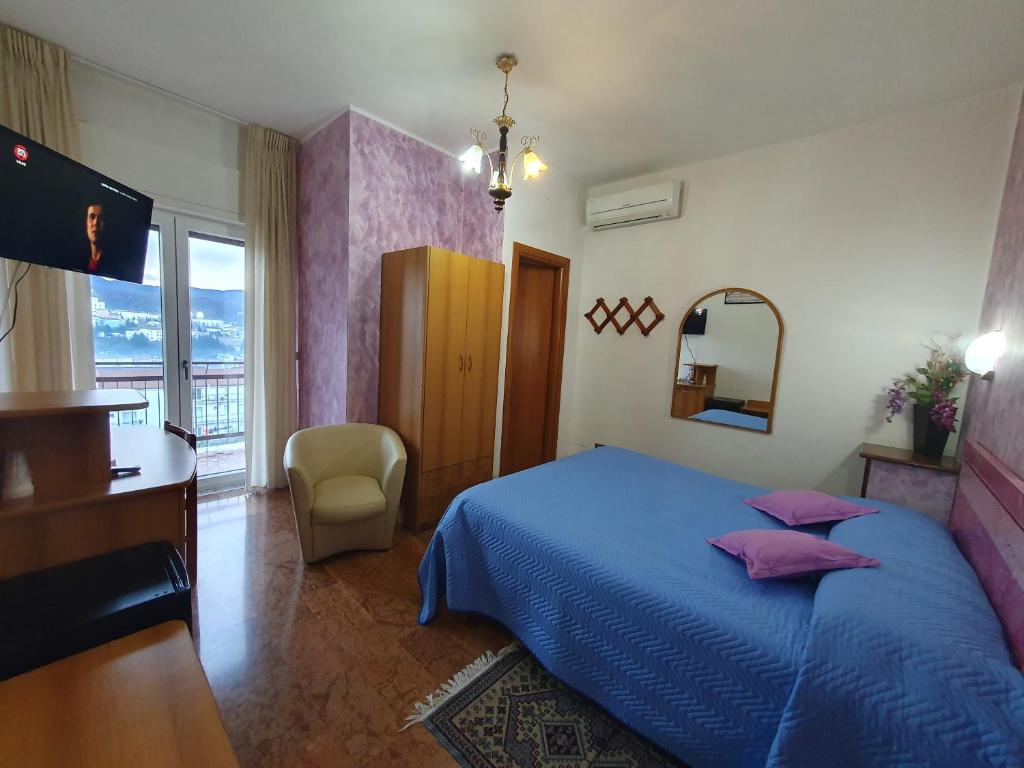 Hotel Ristorante Supersonik في Acri: غرفة نوم بسرير ومكتب وتلفزيون