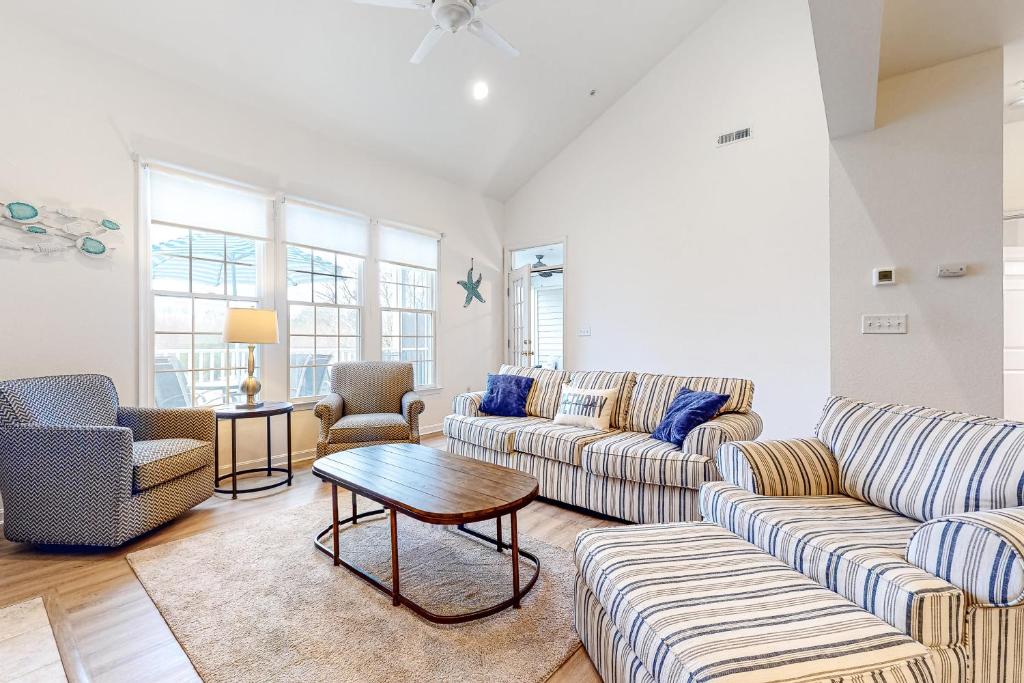 Una sala de estar con dos sofás y una mesa. en Bear Trap Dunes - 210H October Glory Ave, en Ocean View