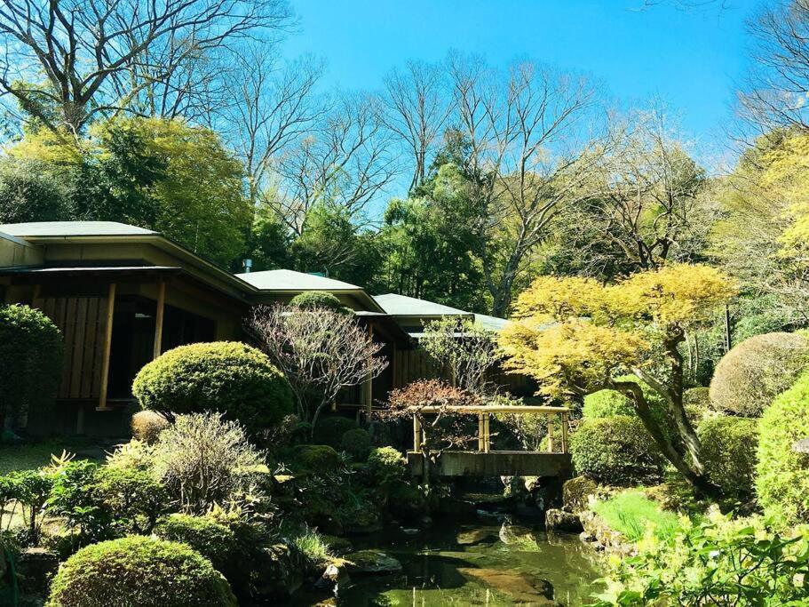 a garden with a house and a pond at 熱海慧薗貸し切り in Atami