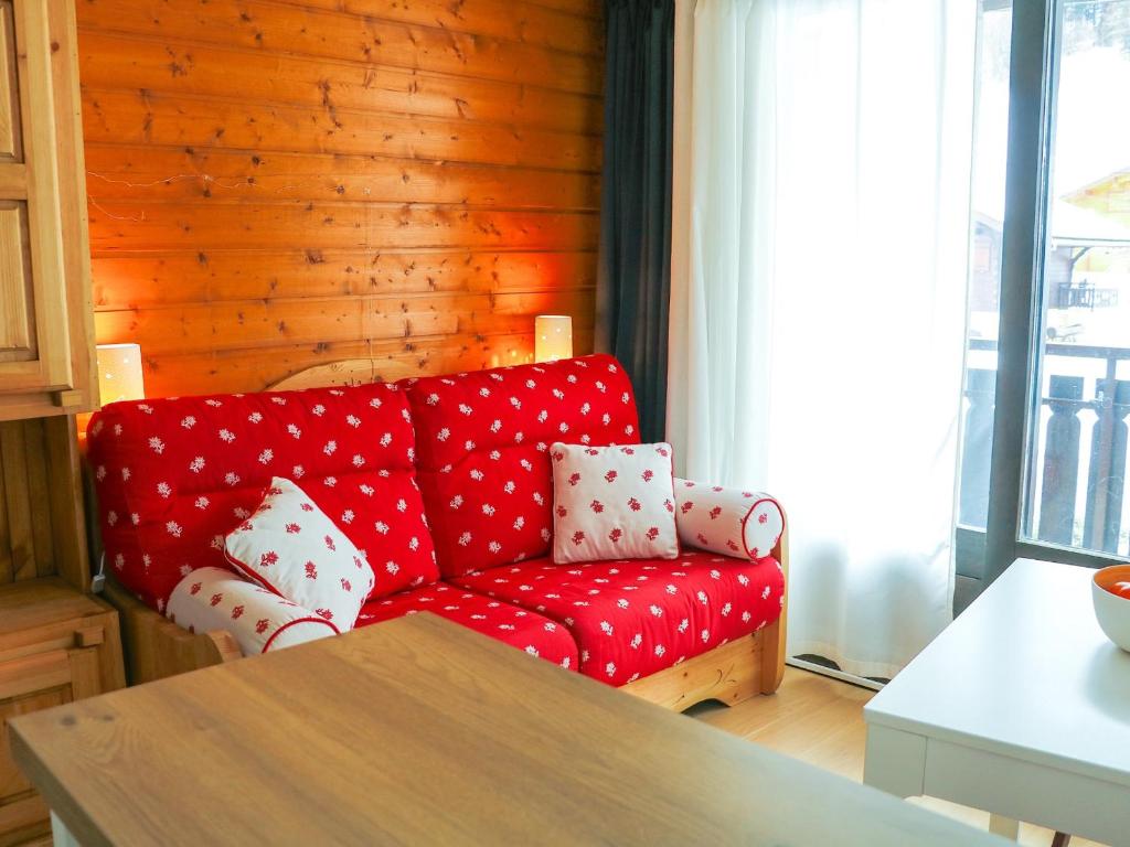- un salon avec un canapé rouge et des oreillers en peluche à la polka dans l'établissement Studio Bernex, 1 pièce, 4 personnes - FR-1-498-71, à Bernex