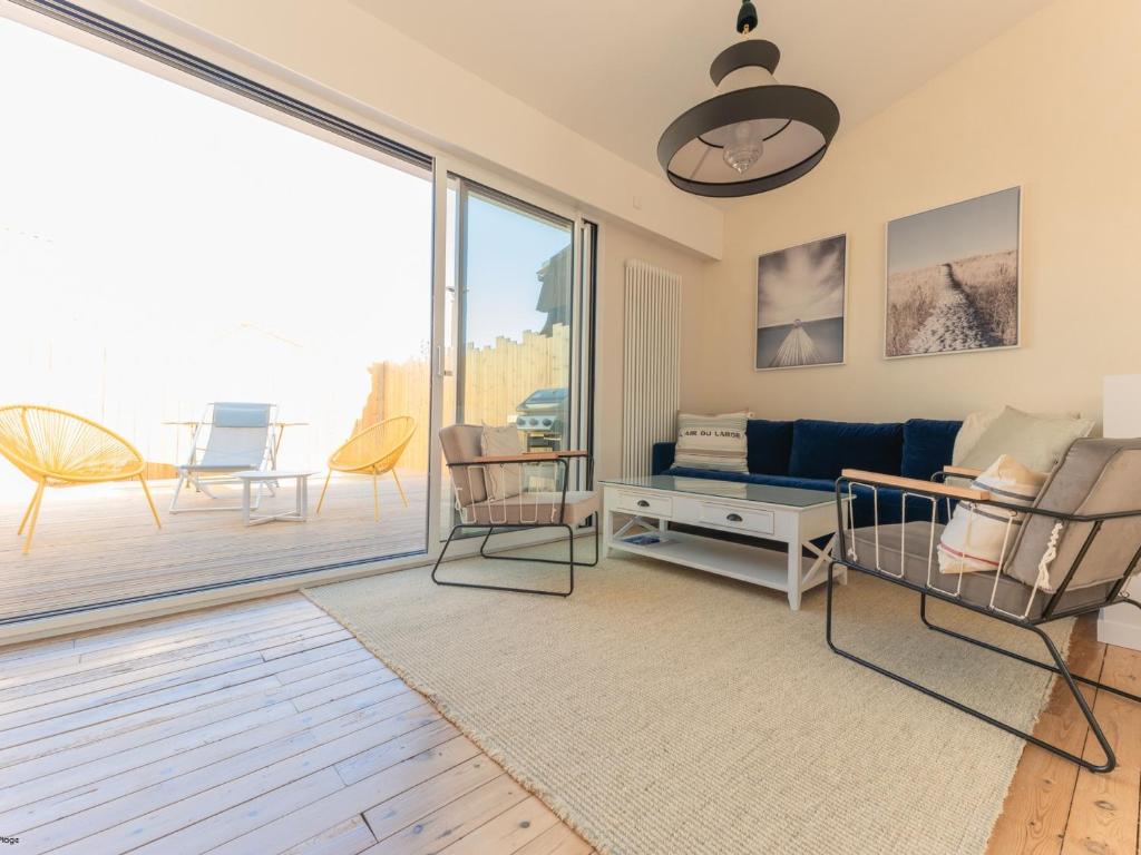 un salon avec un canapé bleu et un balcon dans l'établissement Maison 3 ch. centre-ville, proche plage et marché, 8 pers, 3*, Wi-Fi - FR-1-197-523, à Les Sables-dʼOlonne
