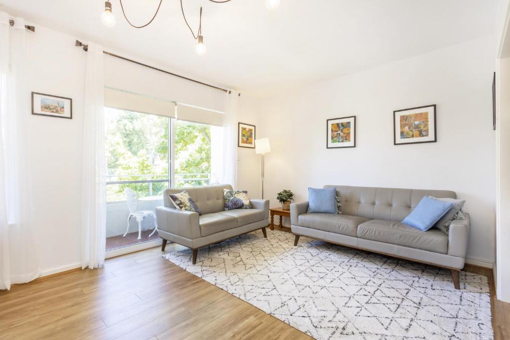 uma sala de estar com dois sofás e uma janela em Zoo View Apartment - EXECUTIVE ESCAPES em Perth
