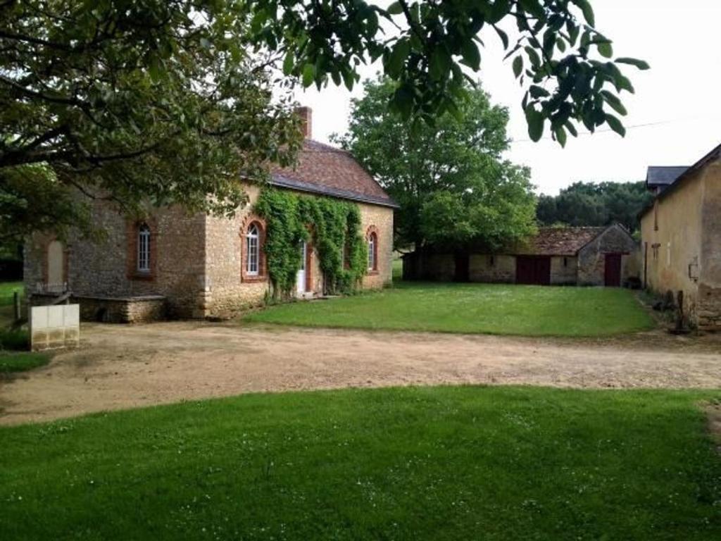 an old brick building with green ivy on it at Gîte familial & authentique avec jardin arboré, entre Angers & Le Mans, idéal visites & détente - FR-1-410-208 in Dureil