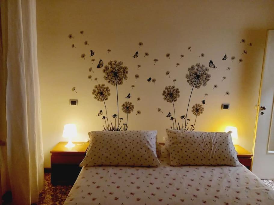 una camera da letto con un letto con fiori sul muro di casa di Angela ad Acqui Terme