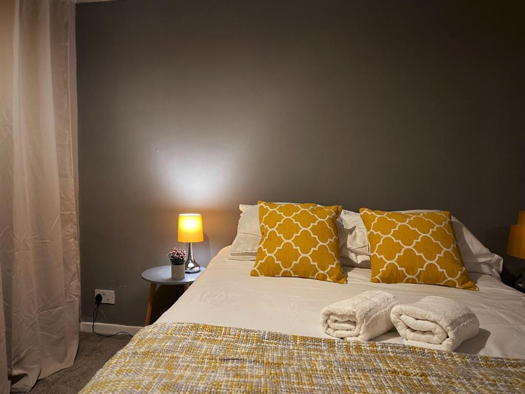 een slaapkamer met een bed met gele en witte kussens bij Vintage 3 Bedroom House near Catford in Londen