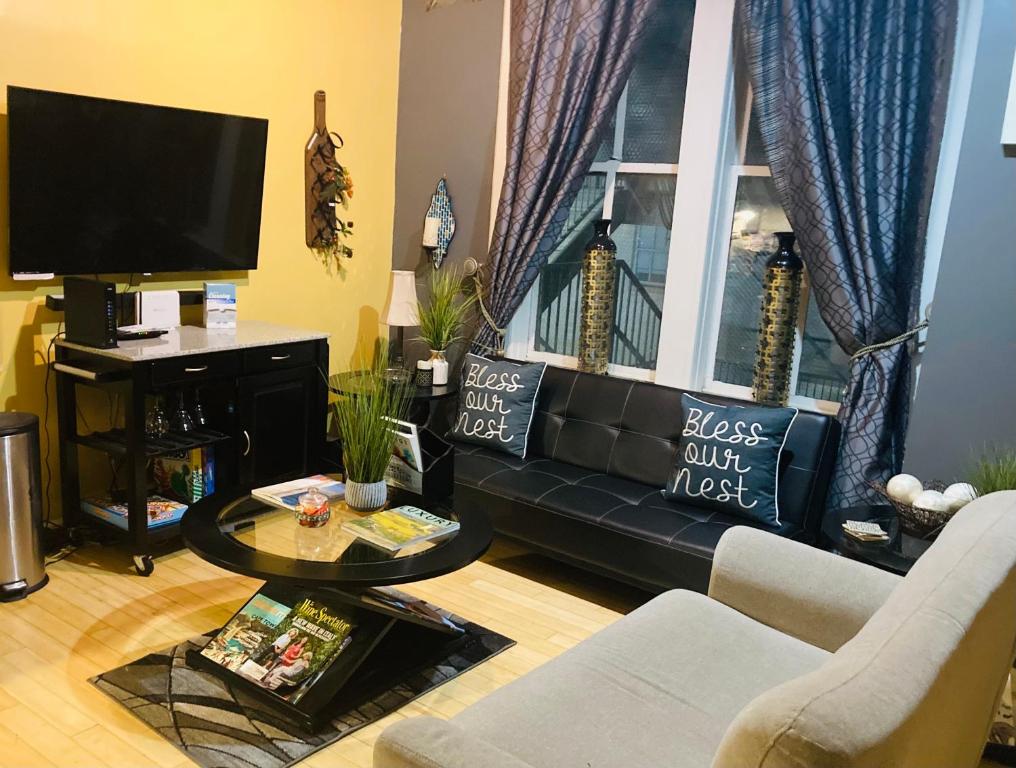 a living room with a black couch and a window at The Samone's in Atlanta