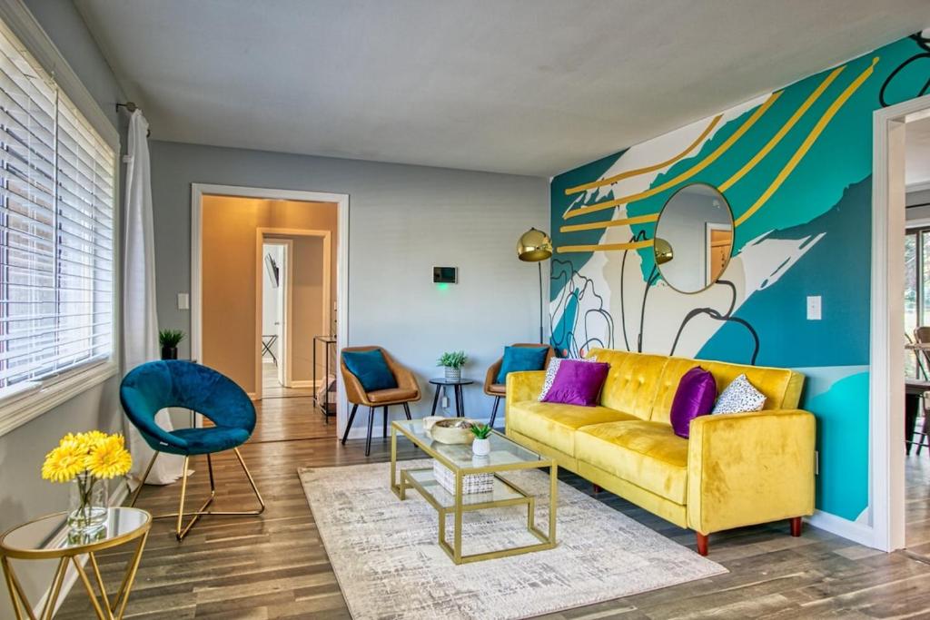 sala de estar con sofá amarillo y pared colorida en Atlanta Decatur Rocksteadymessagespring Special!, en Decatur