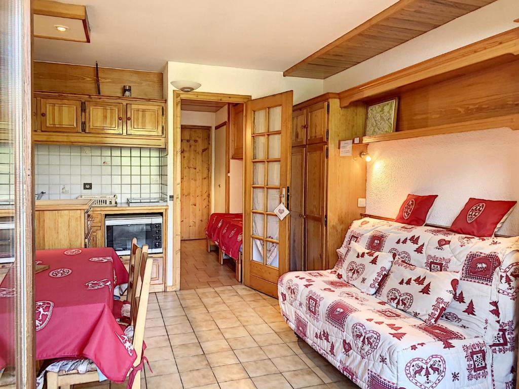 a bedroom with a bed and a table and a kitchen at Studio cosy pour 3 avec terrasse, parking et casier à ski à Combloux - FR-1-560-77 in Combloux