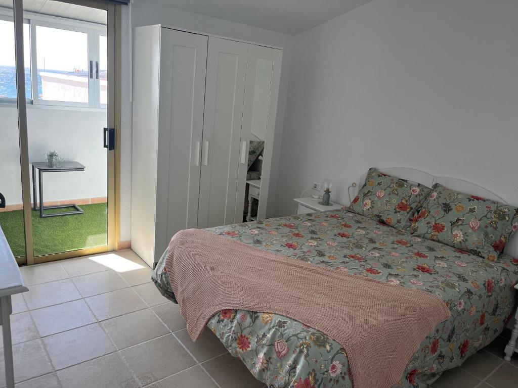 a bedroom with a bed and a sliding glass door at La Arena VII in Los Abrigos