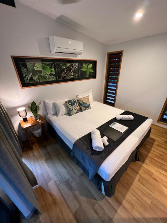 um quarto com uma cama grande com duas toalhas em Safari Lodge em Cape Tribulation