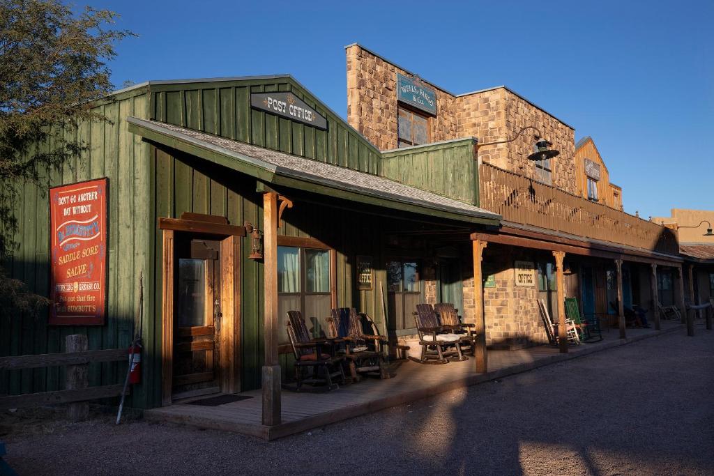 un edificio antiguo con sillas fuera de él en Tombstone Monument Guest Ranch, en Tombstone