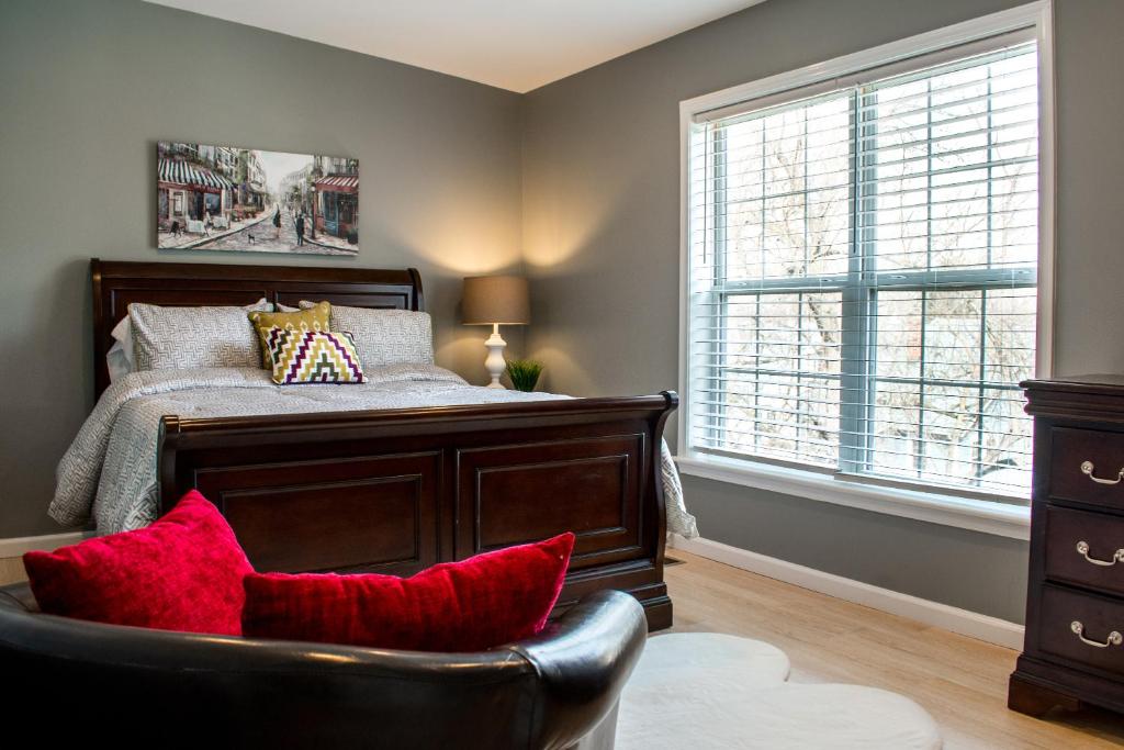 een slaapkamer met een bed met rode kussens en een stoel bij Cozy condo with yard and patio. Long-stay discount available in Fairfield