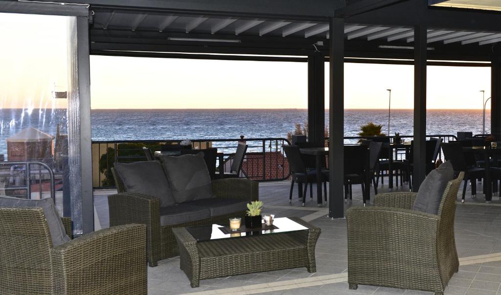 eine Terrasse mit Stühlen und Tischen und Meerblick in der Unterkunft Villa Le Logge in Ventimiglia