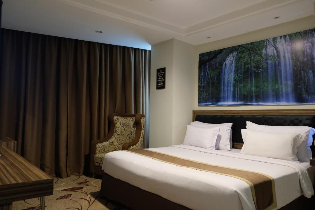 una camera d'albergo con un grande letto e un pianoforte di Travellers Hotel Phinisi a Makassar