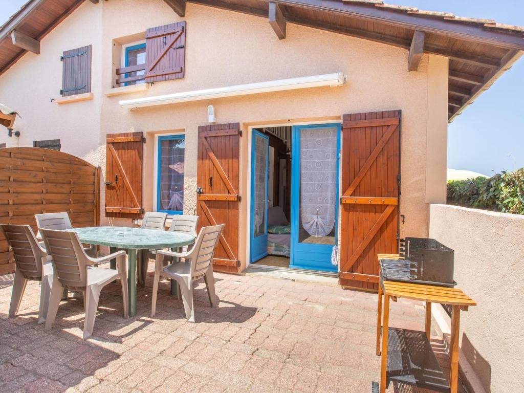 un patio avec une table et des chaises devant une maison dans l'établissement Maison T2 Mezzanine à 350m des Plages avec Terrasse et Parking à Biscarrosse - FR-1-521-182, à Biscarrosse