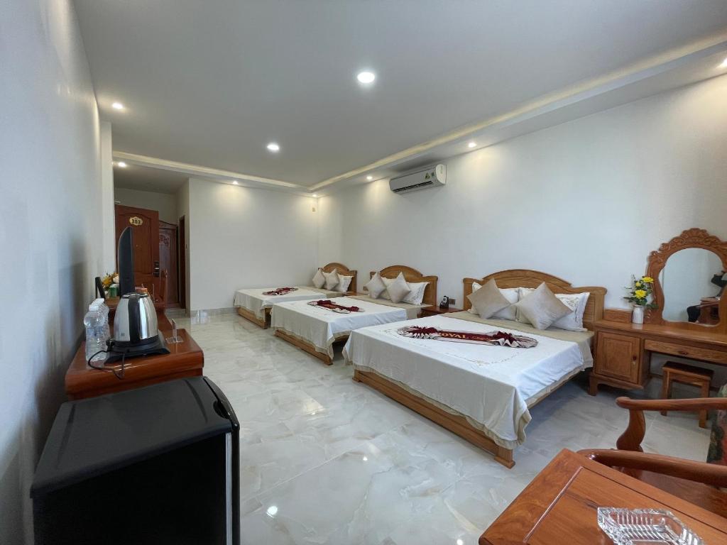 Royal Hotel 2 في Bạc Liêu: غرفة فندقية بسريرين وتلفزيون