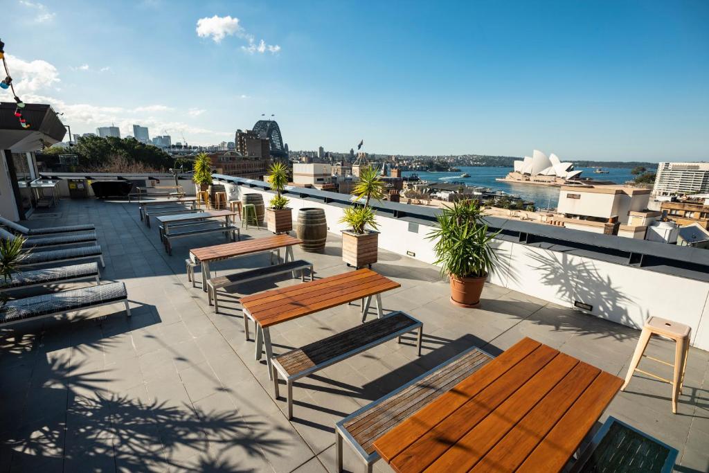 un groupe de bancs et de tables sur un toit dans l'établissement YHA Sydney Harbour, à Sydney